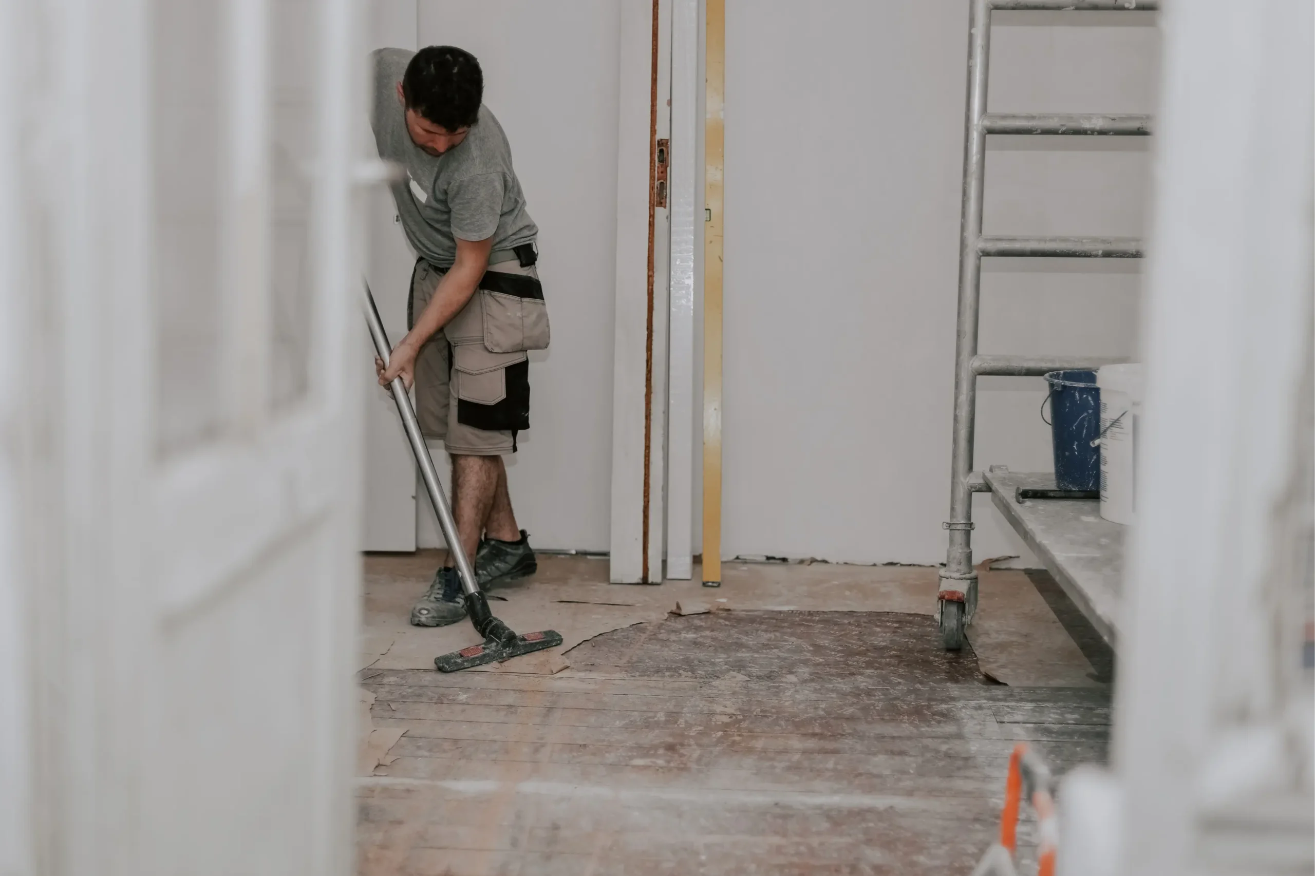 young-man-vacuums-floor-with-construction-vacuum-cleaner